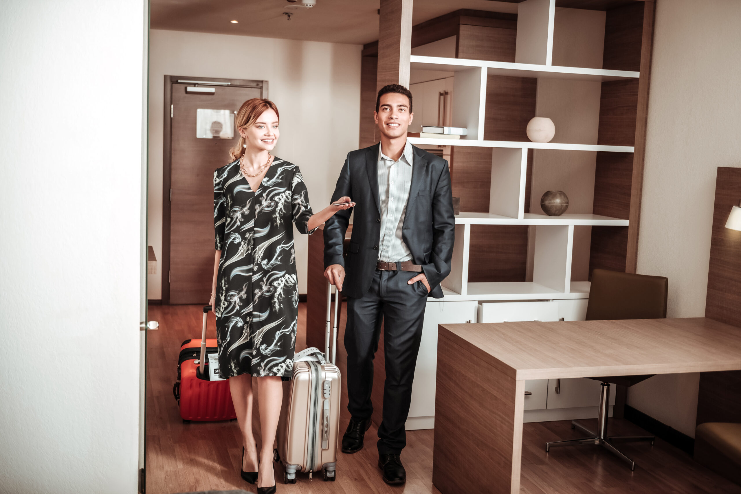 Wife and husband. Stylish wife and husband feeling excited while entering their hotel room